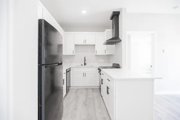 a kitchen with a sink a refrigerator and cabinets