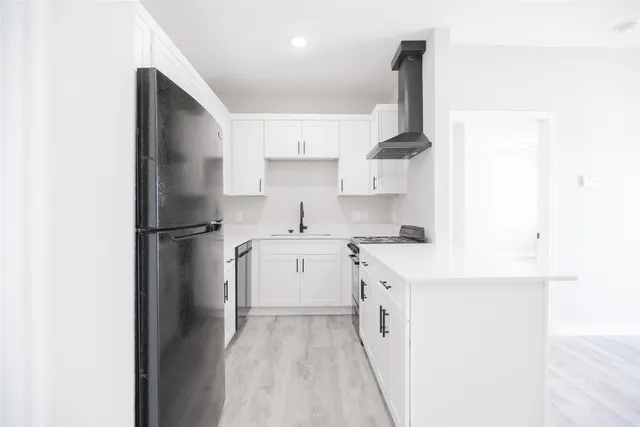 a kitchen with a sink a refrigerator and cabinets