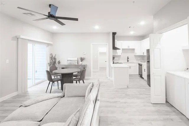 a living room with stainless steel appliances kitchen island granite countertop furniture and a dining table