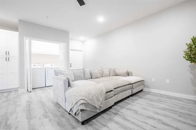 a living room with furniture and a wooden floor