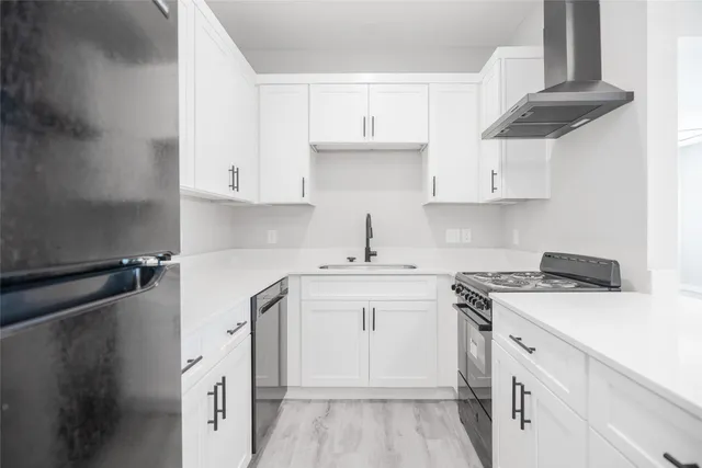 a kitchen with cabinets appliances a sink and a counter top