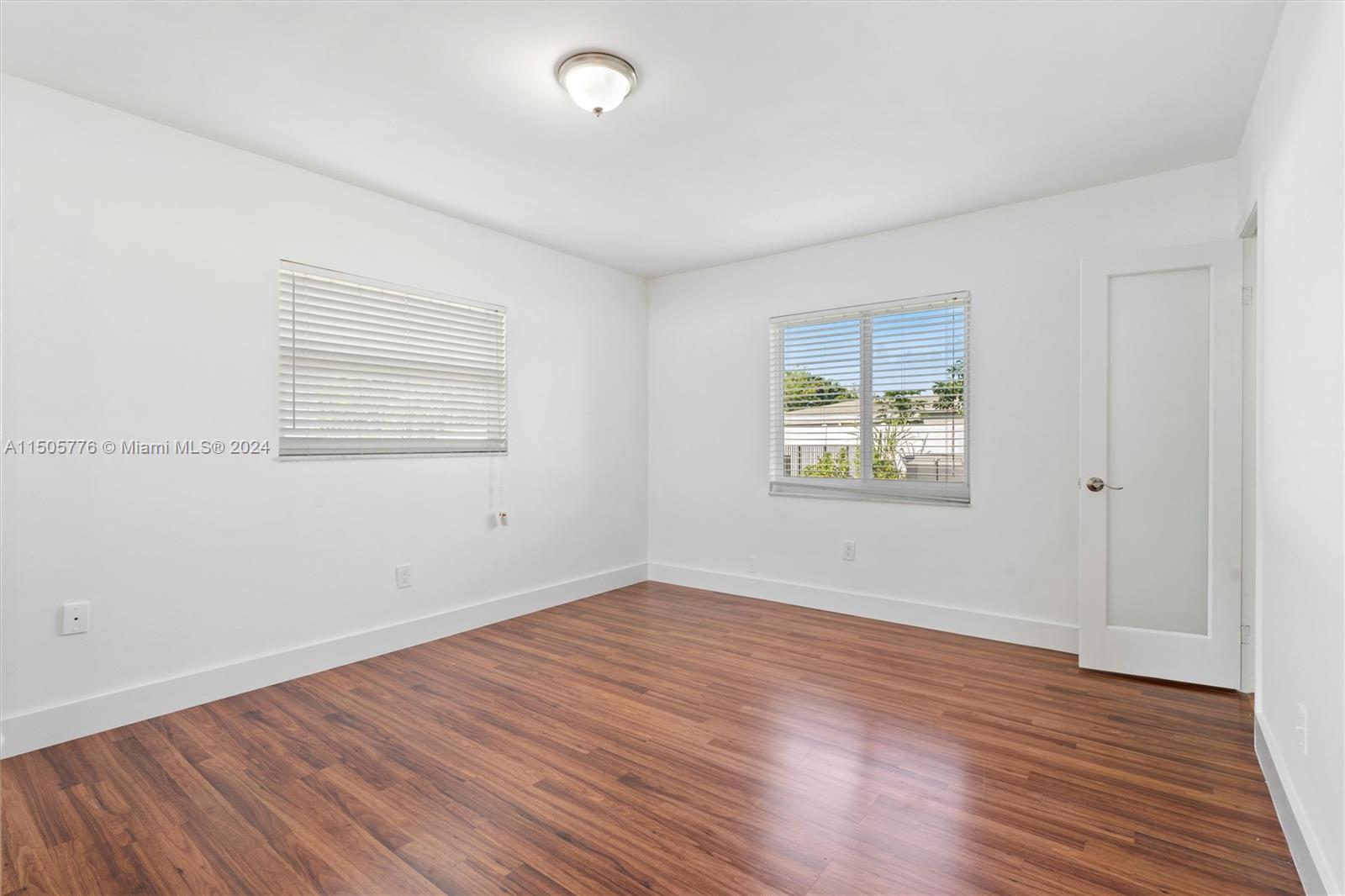 11126 Delta Circle Boca Raton, FL 33428 - Photo 11 of 22 an empty room with wooden floor and windows