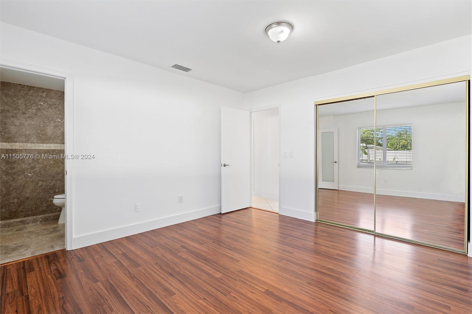 11126 Delta Circle Boca Raton, FL 33428 - Photo 12 of 22 an empty room with wooden floor and windows
