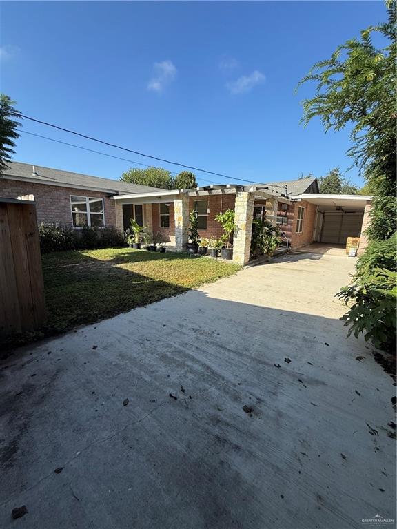 708 North 6th Street McAllen, TX 78501 - Photo 21 of 27 Single story home with a front lawn, driveway, brick siding, and an attached carport