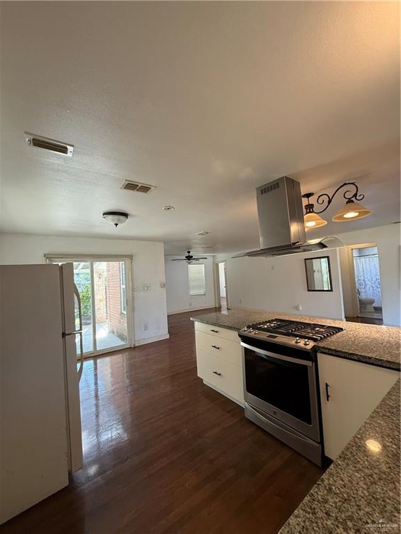 708 North 6th Street McAllen, TX 78501 - Photo 7 of 27 Kitchen featuring white range oven, refrigerator, dark wood-type flooring, dark stone counters, and extractor fan