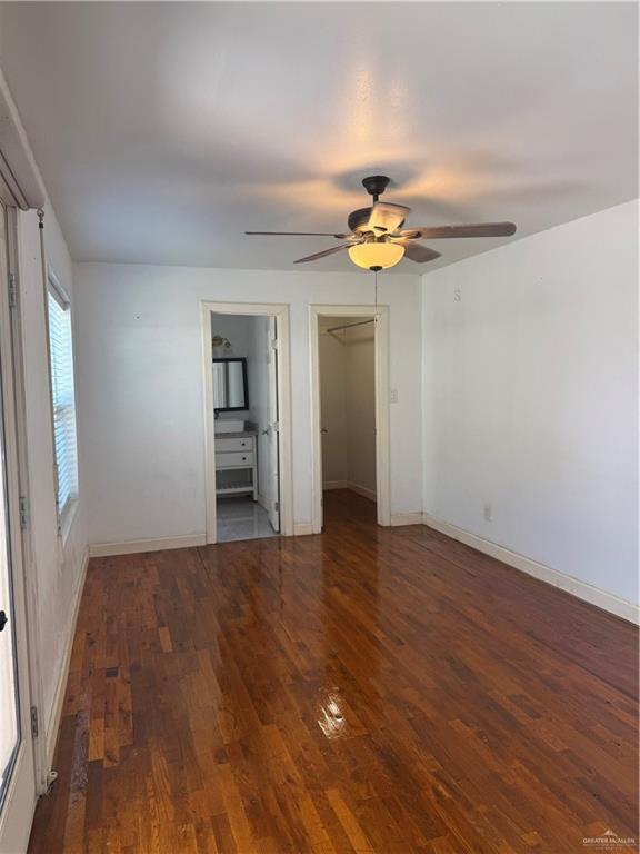 708 North 6th Street McAllen, TX 78501 - Photo 8 of 27 Unfurnished bedroom with a walk in closet, dark wood-style flooring, ceiling fan, and ensuite bathroom