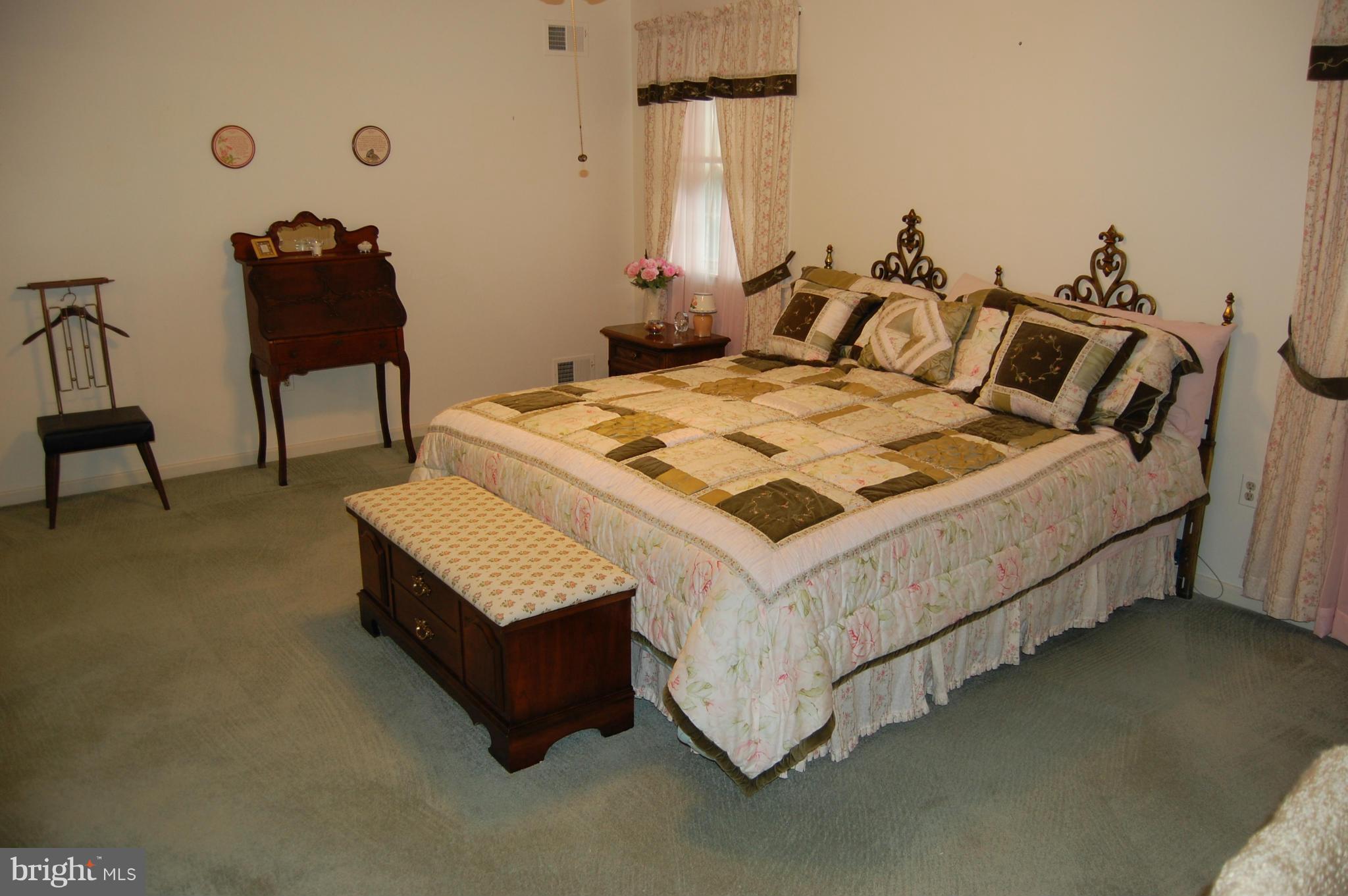 2209 Parallel Lane Silver Spring, MD 20904 - Photo 9 of 30 a bed sitting in a bedroom next to a chair and a chandelier