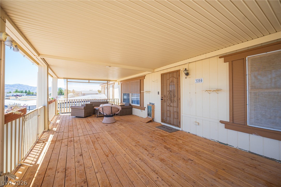 3200 Maple Road Pahrump, NV 89048 - Photo 5 of 53 A vast covered porch with natural wood flooring offers serene mountain views and an ideal space for outdoor enjoyment.