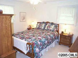 3079 Lake Shore Road South Denver, NC 28037 - Photo 6 of 8 a bed sitting in a bedroom next to a window with lamp