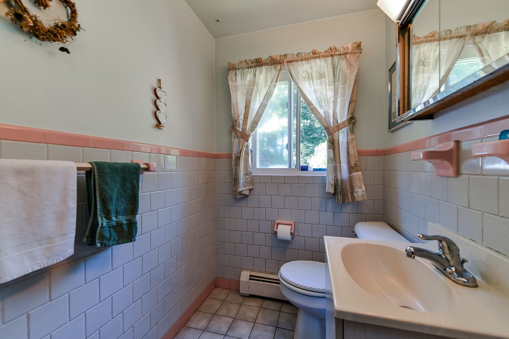259 Potter Road Framingham, MA 01701 - Photo 8 of 23 a bathroom with a sink toilet a mirror and tub