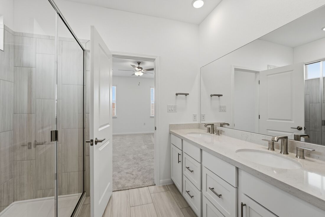 1712 Lorant Lane Pflugerville, TX 78660 - Photo 14 of 36 a spacious bathroom with a granite countertop sink a mirror and shower