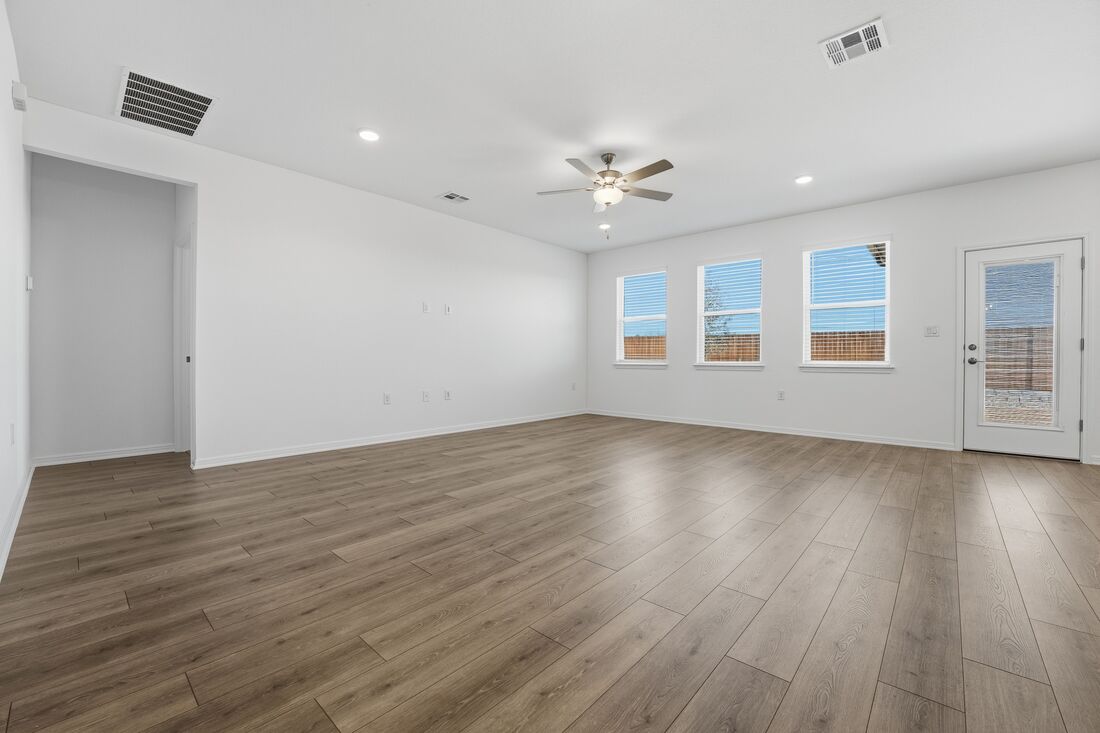 1712 Lorant Lane Pflugerville, TX 78660 - Photo 6 of 36 a view of an empty room with wooden floor and a window
