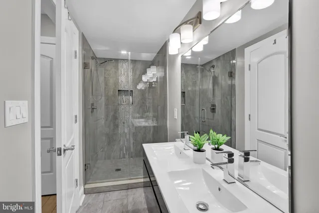 a bathroom with a sink a shower and a mirror
