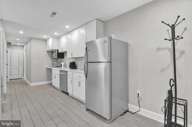 a kitchen with white cabinets and white appliances