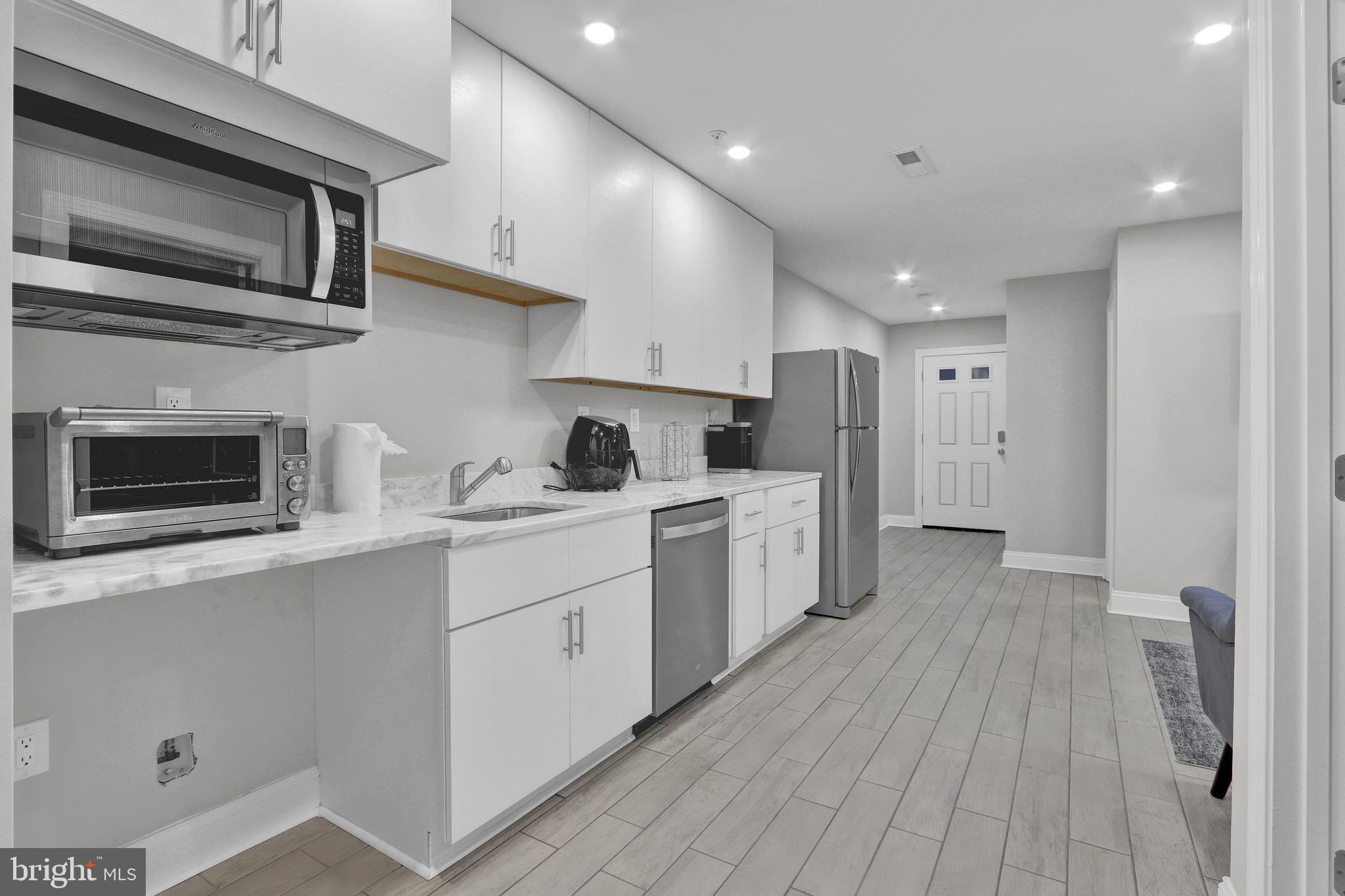 1167 Morse Street Northeast, Unit B1 Washington, DC 20002 - Photo 8 of 18 a kitchen with a sink microwave and refrigerator