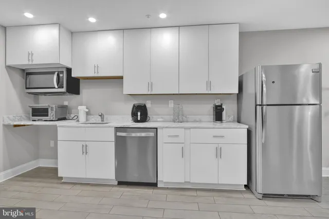 a kitchen with a refrigerator and a stove top oven