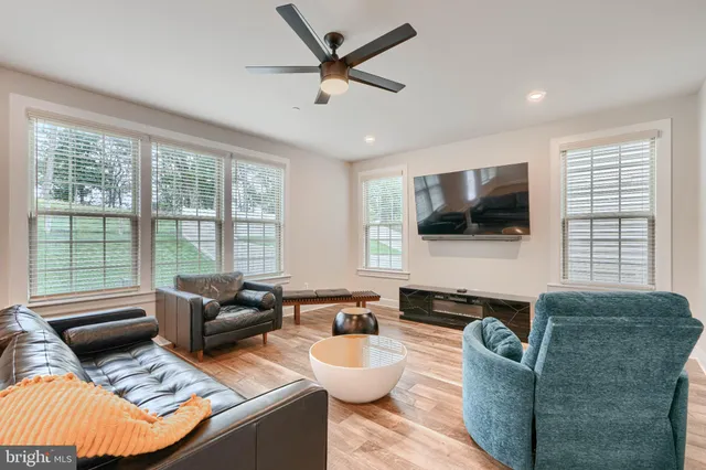 a living room with furniture and a ceiling fan