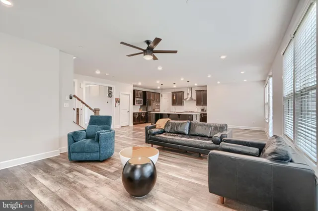 a kitchen with a stove a sink a kitchen island with wooden floor and cabinets