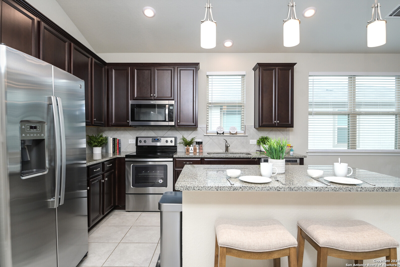 2411 Verona Way San Antonio, TX 78259 - Photo 2 of 22 a kitchen with stainless steel appliances granite countertop a stove a sink a microwave a refrigerator and cabinets