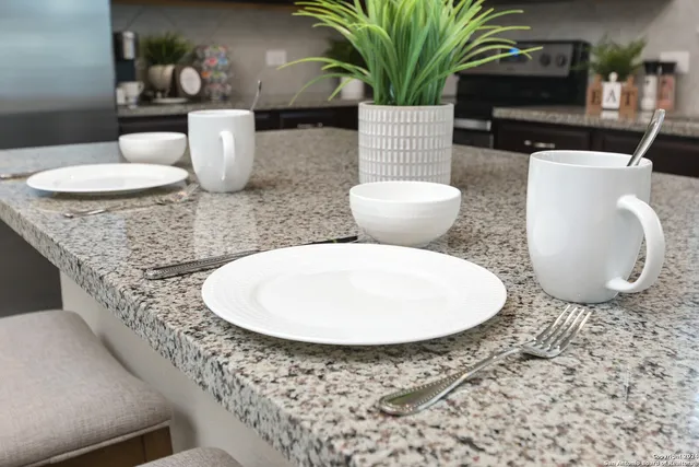 a bathroom with a granite countertop sink and a mirror