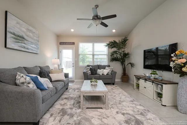 a living room with furniture a flat screen tv and a large window