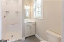 a bathroom with a granite countertop sink a toilet and shower