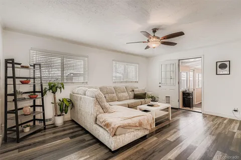 a living room with furniture a ceiling fan and a window