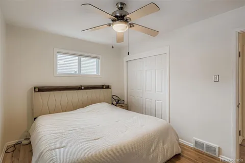 a bedroom with a white bed and a ceiling fan