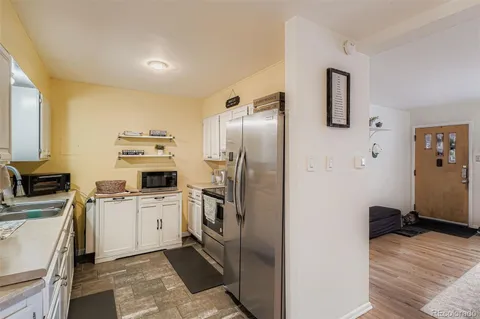 a kitchen with a sink a refrigerator and cabinets