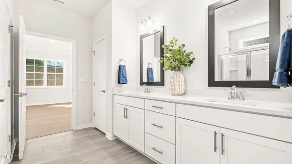 a bathroom with a double vanity sink and a mirror