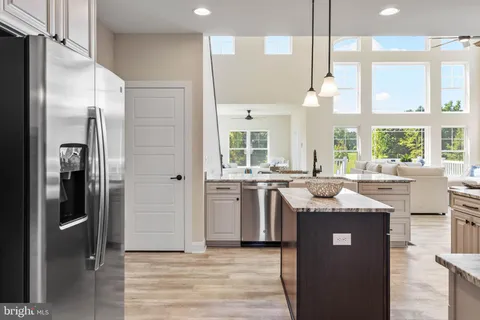 a view of a kitchen with granite countertop a large window cabinets and stainless steel appliances