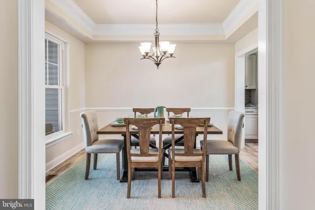 a view of a dining room with furniture a chandelier and wooden floor