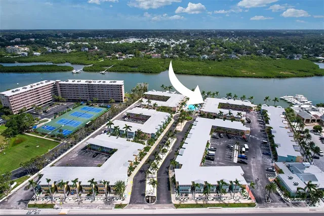 an aerial view of a city with lots of residential buildings ocean and mountain view in back