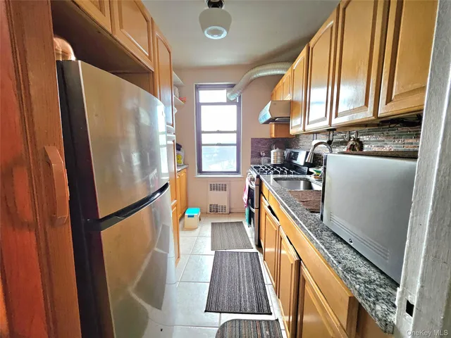 a kitchen with stainless steel appliances a refrigerator a sink a stove and cabinets
