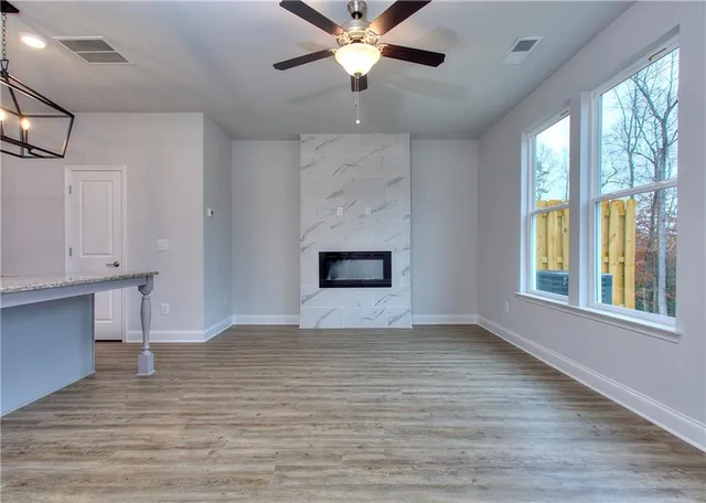 a view of an empty room with a window and wooden floor