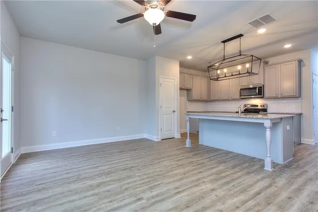 a view of kitchen with refrigerator microwave and stove