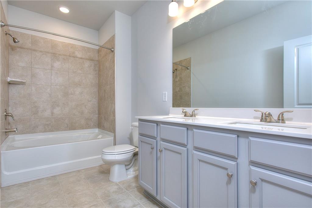 115 Greenview Court Homer, GA 30547 - Photo 22 of 32 a bathroom with a double vanity sink toilet mirror and shower