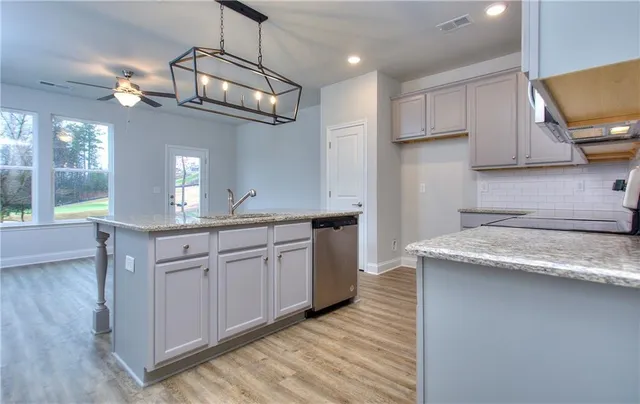 a kitchen with granite countertop cabinets a sink a window and stainless steel appliances