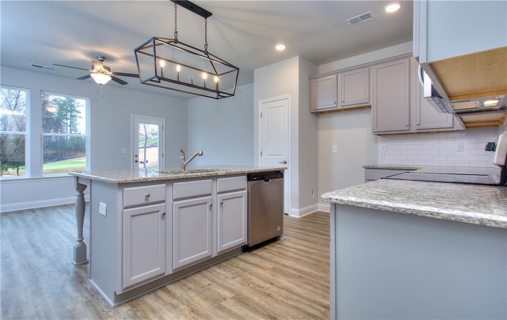 115 Greenview Court Homer, GA 30547 - Photo 4 of 32 a kitchen with granite countertop cabinets a sink a window and stainless steel appliances