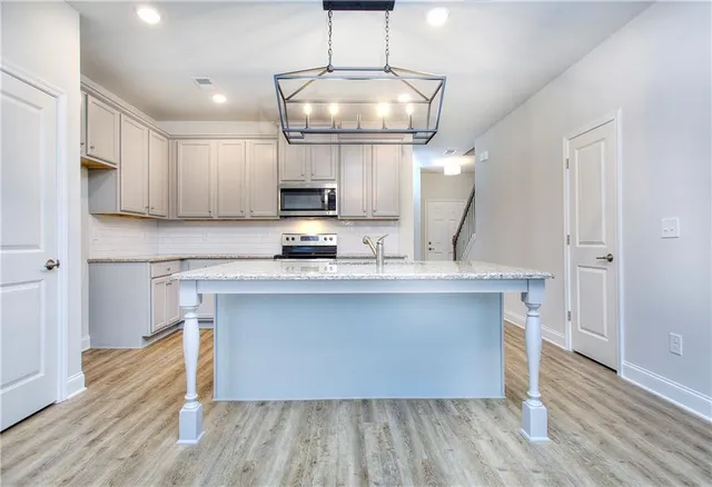 a kitchen with kitchen island a counter space a sink and appliances