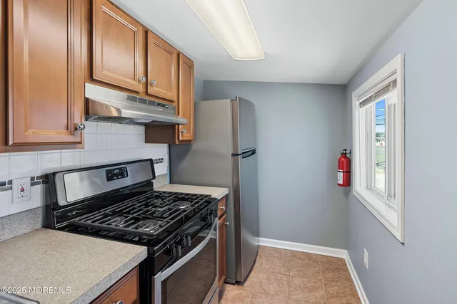 a kitchen with stainless steel appliances granite countertop a refrigerator and a stove top oven