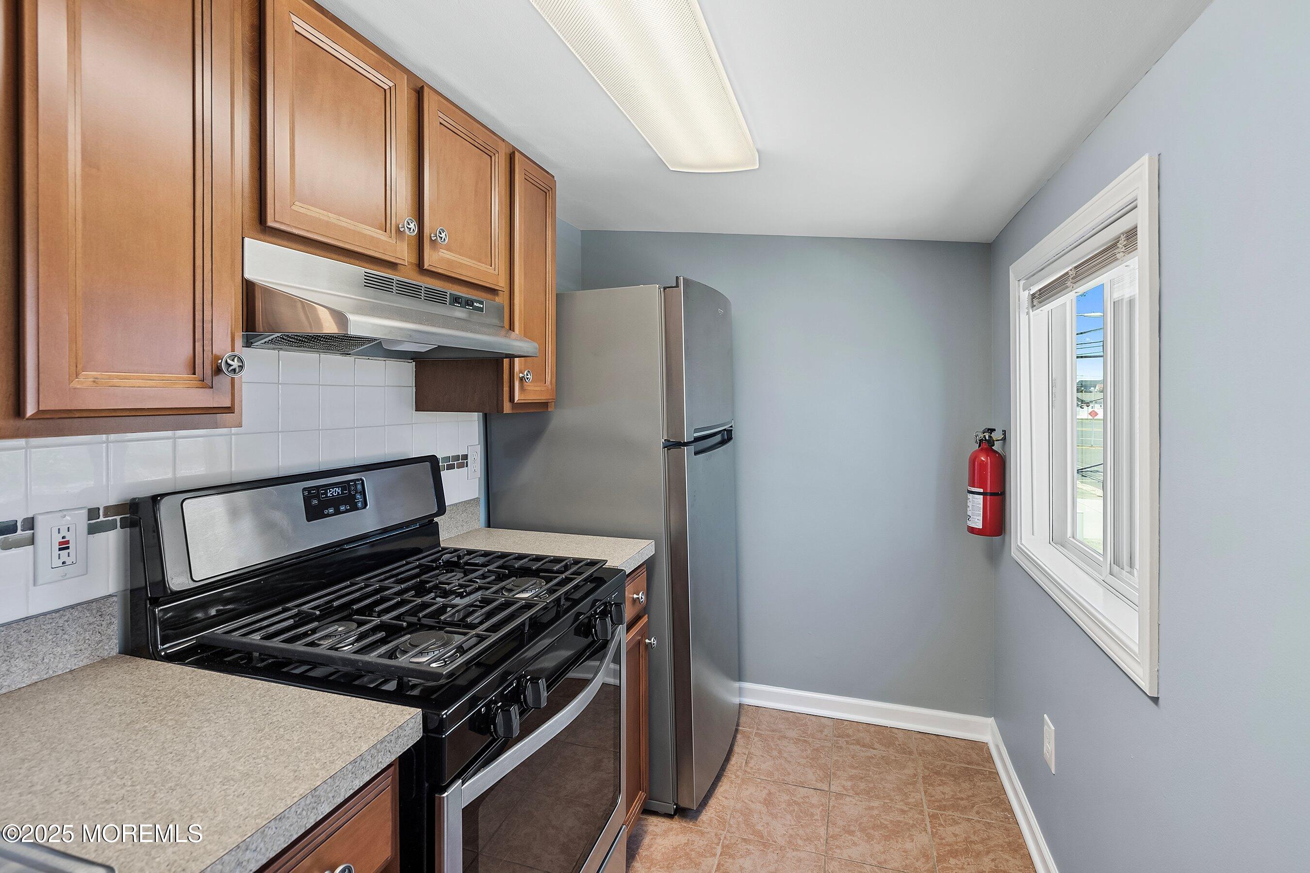 309 Hiering Avenue, Unit A Seaside Heights, NJ 08751 - Photo 5 of 18 a kitchen with stainless steel appliances granite countertop a refrigerator and a stove top oven