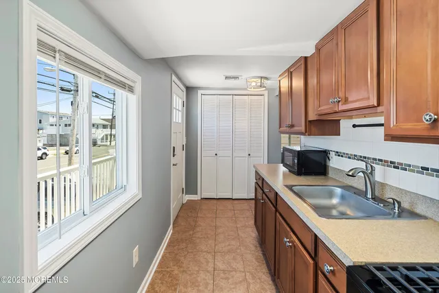 a kitchen with kitchen island granite countertop a sink stove and cabinets