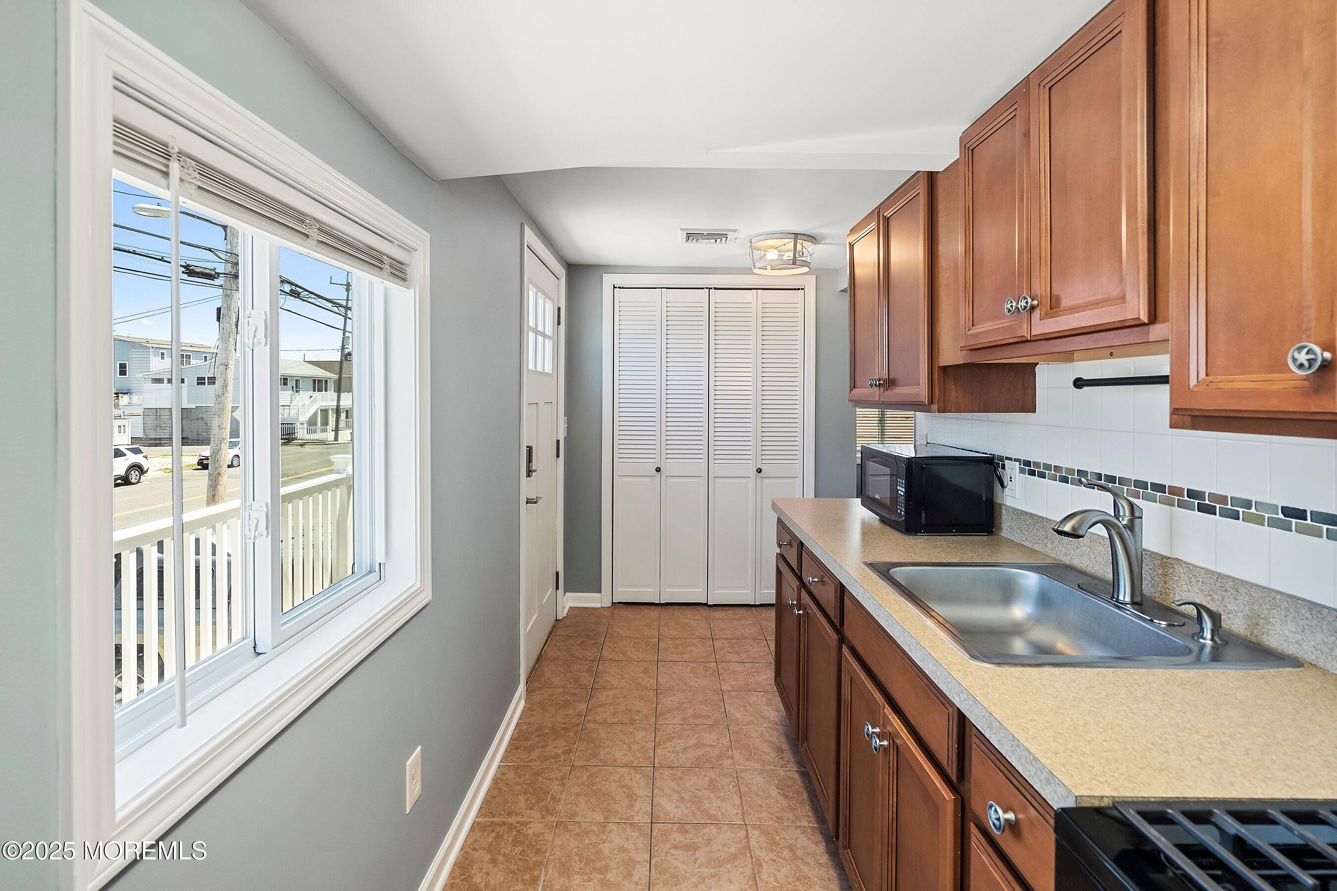 309 Hiering Avenue, Unit A Seaside Heights, NJ 08751 - Photo 7 of 18 a kitchen with kitchen island granite countertop a sink stove and cabinets