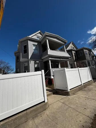 a view of a large house with wooden fence