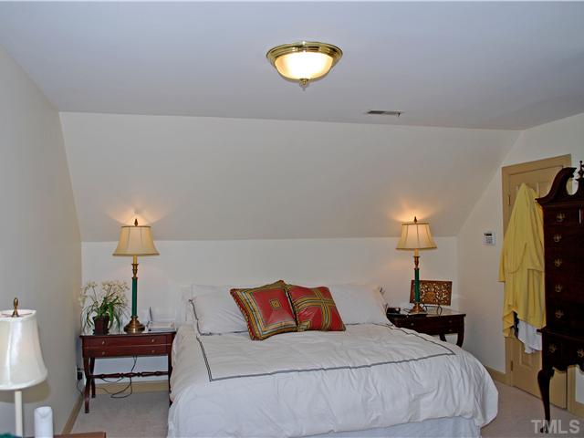 1306 Hampshire Court Raleigh, NC 27612 - Photo 10 of 12 a bedroom with a bed and a lamp