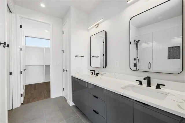 a bathroom with double vanity sinks double vanity tub and a mirror