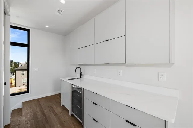 a kitchen with a sink cabinets and a wooden floor