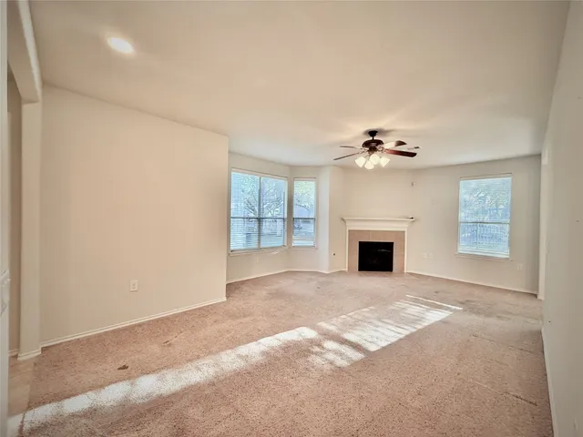 a view of a livingroom with a fireplace and chandelier fan