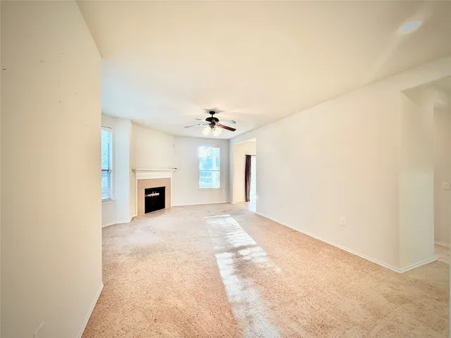 an empty room with windows and fireplace